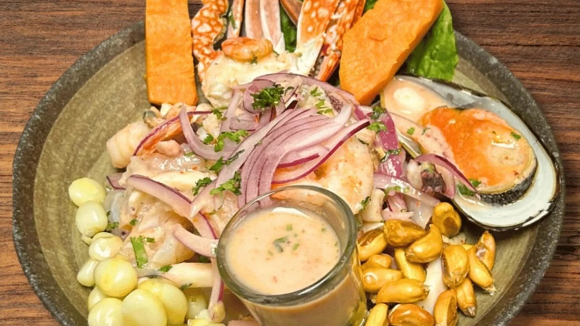 Ceviche mixto with fish, shrimp, crab and mussels, served with choclo, cancha, sweet potato and a shot of leche de tigre